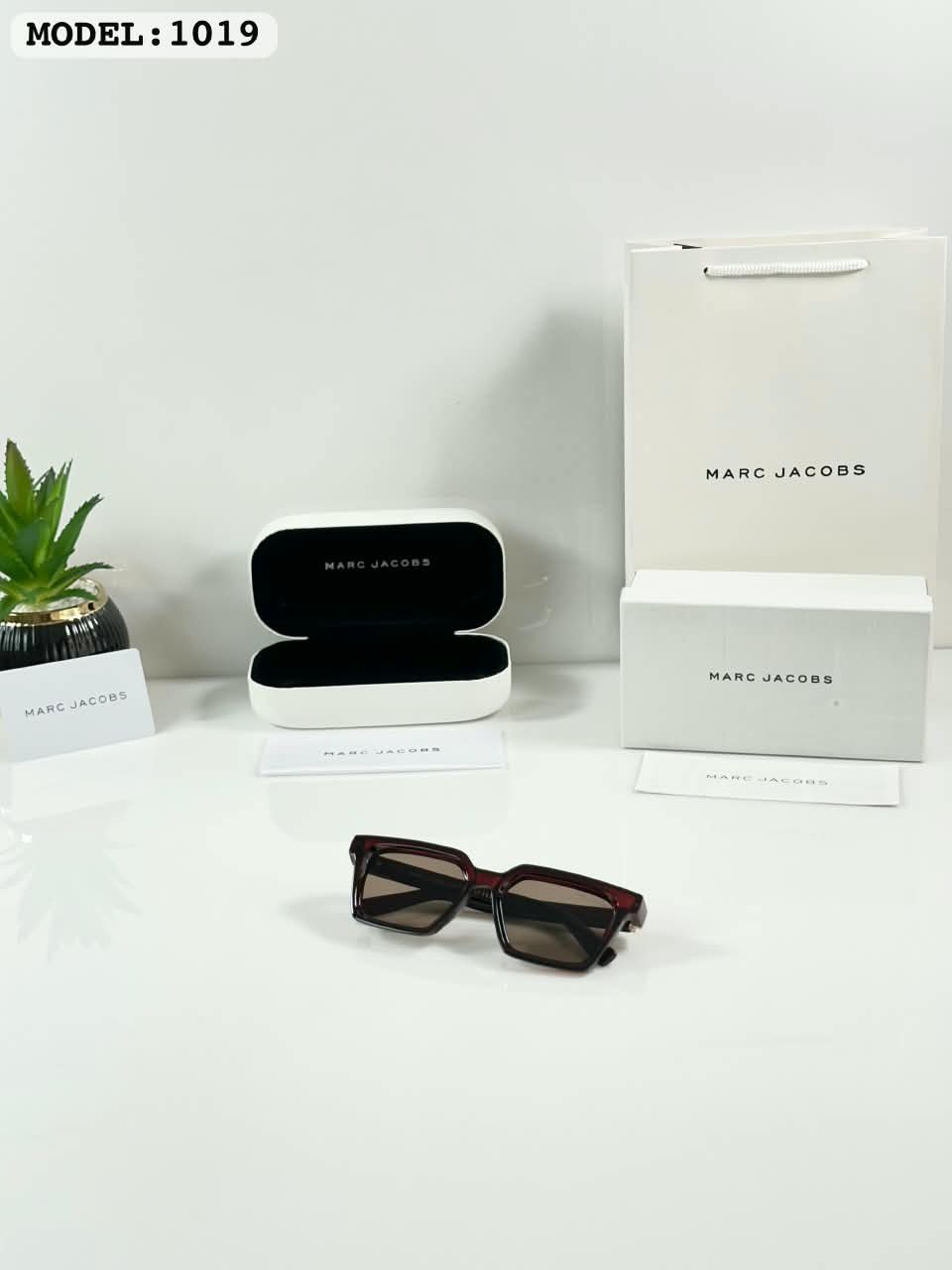 Brown Frame Sunglasses – Tortoise Tone Accents (2) Dark brown rectangular sunglasses with brown-tinted lenses and metallic temple accents