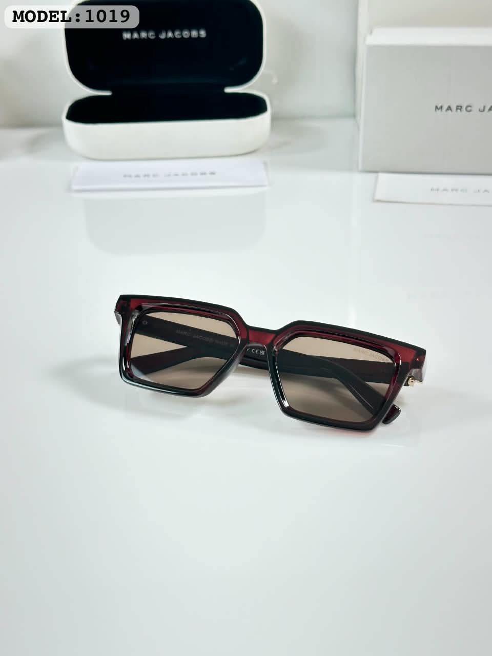 Brown Frame Sunglasses – Tortoise Tone Accents (3) Dark brown rectangular sunglasses with brown-tinted lenses and metallic temple accents