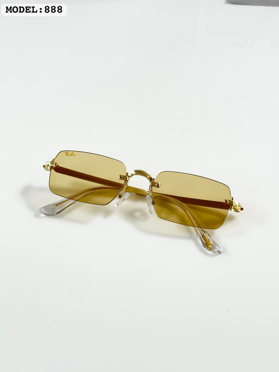 Rimless Rectangle Sunglasses – Gold Frame with Light Yellow Lenses (3) Rimless rectangular sunglasses with a gold-tone metal frame and light yellow lenses