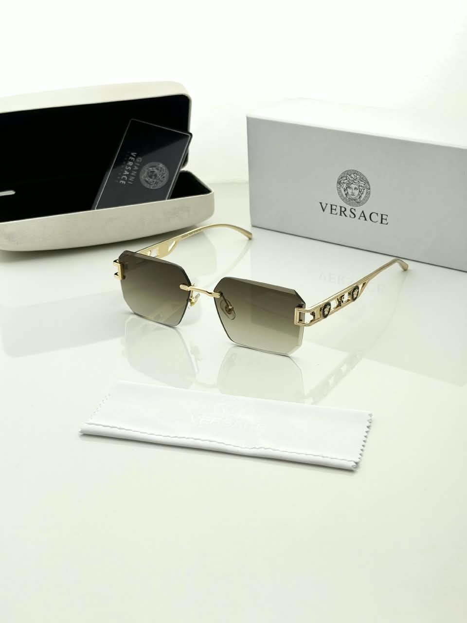 Rimless Square Sunglasses – Gold Tone Frame Details (1) Rimless square sunglasses with gold-tone metal details and shaded grey-brown lenses