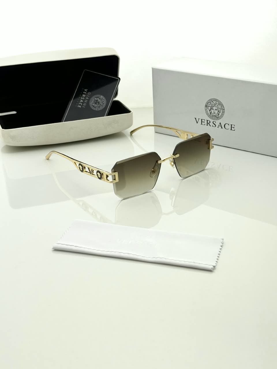 Rimless Square Sunglasses – Gold Tone Frame Details (2) Rimless square sunglasses with gold-tone metal details and shaded grey-brown lenses