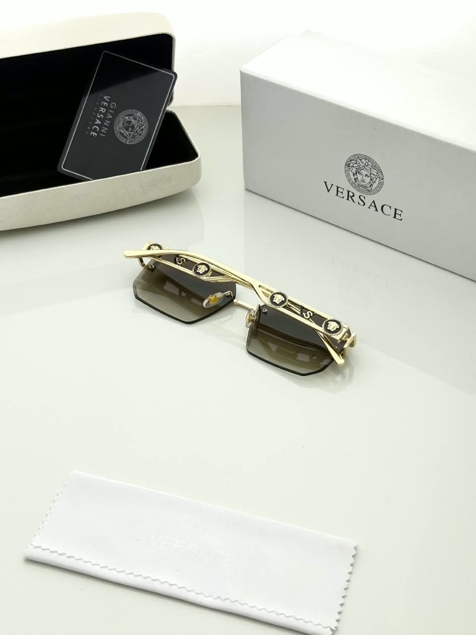 Rimless Square Sunglasses – Gold Tone Frame Details (3) Rimless square sunglasses with gold-tone metal details and shaded grey-brown lenses