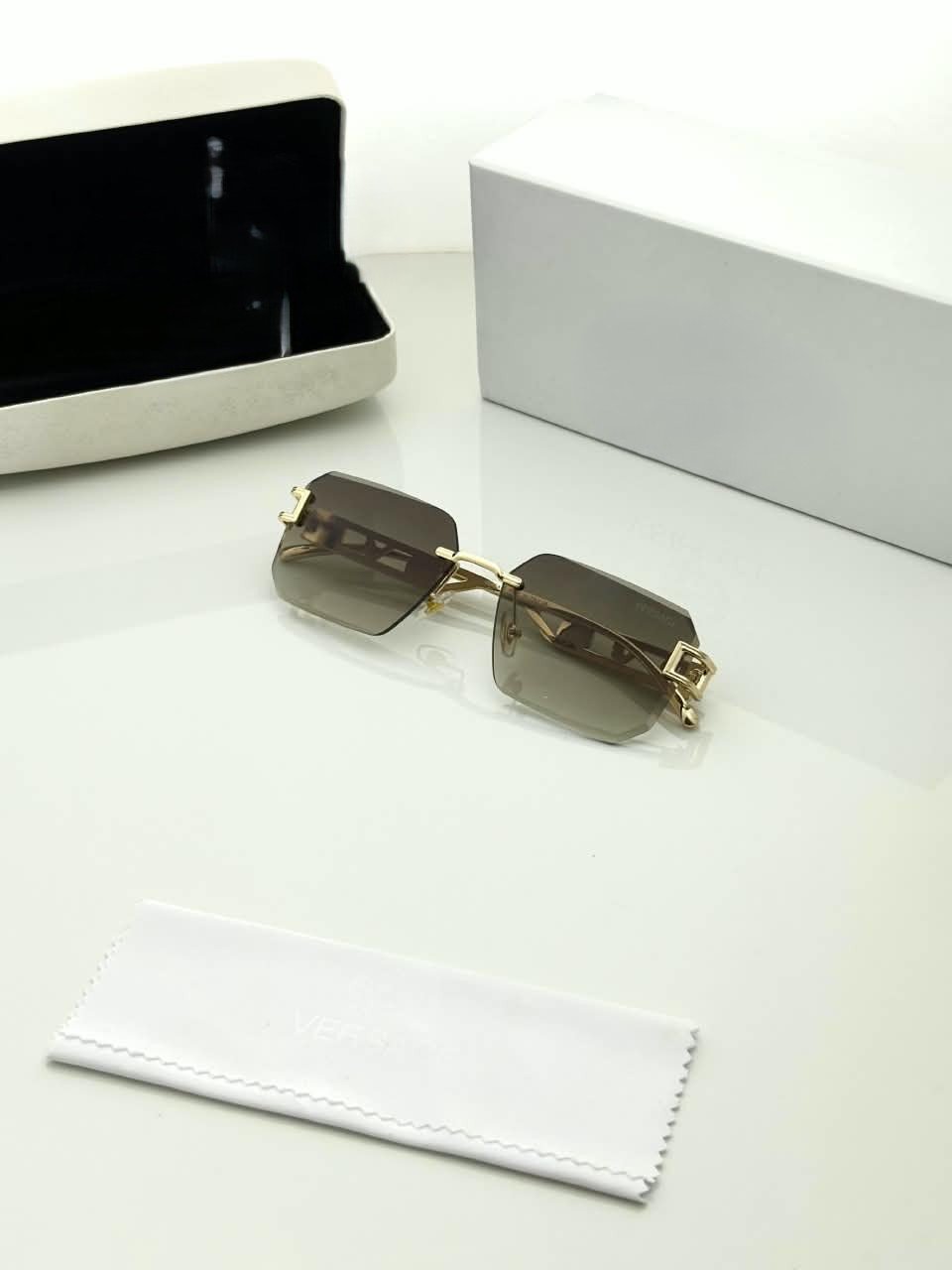Rimless Square Sunglasses – Gold Tone Frame Details (4) Rimless square sunglasses with gold-tone metal details and shaded grey-brown lenses