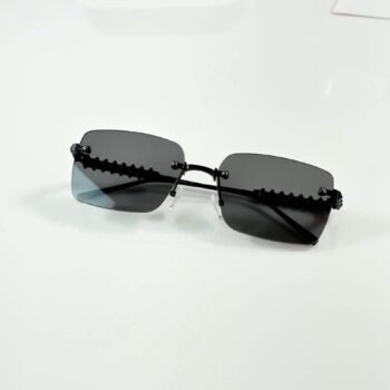 Black rimless rectangular sunglasses with dark lenses and textured temples