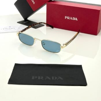 Slim rectangular sunglasses with a gold-tone frame, blue lenses, and brown patterned temples