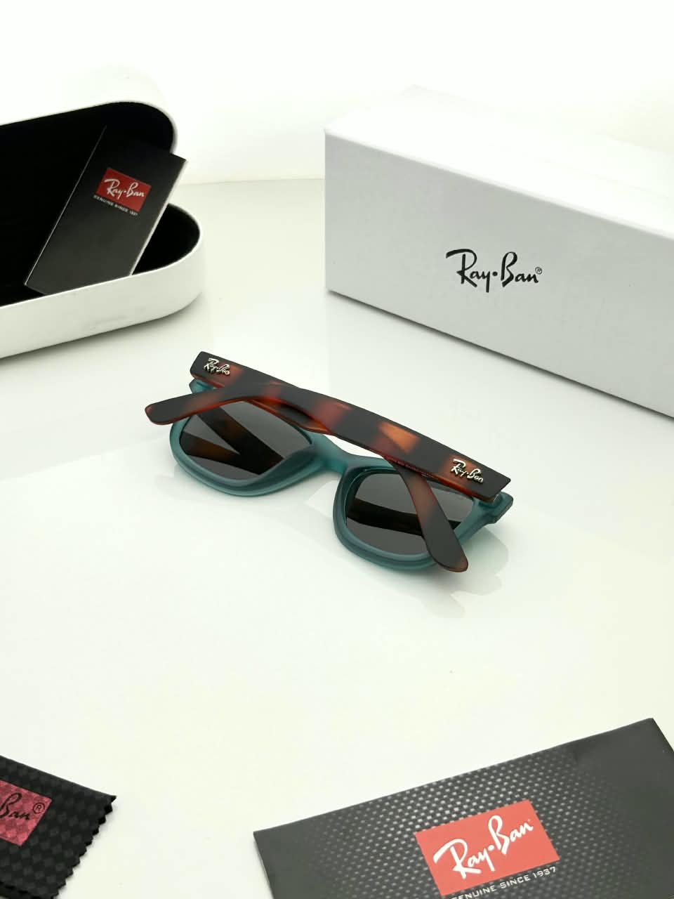 Teal Frame Sunglasses – Dark Grey Lenses (3) Teal rectangular sunglasses with dark grey lenses and brown patterned temples