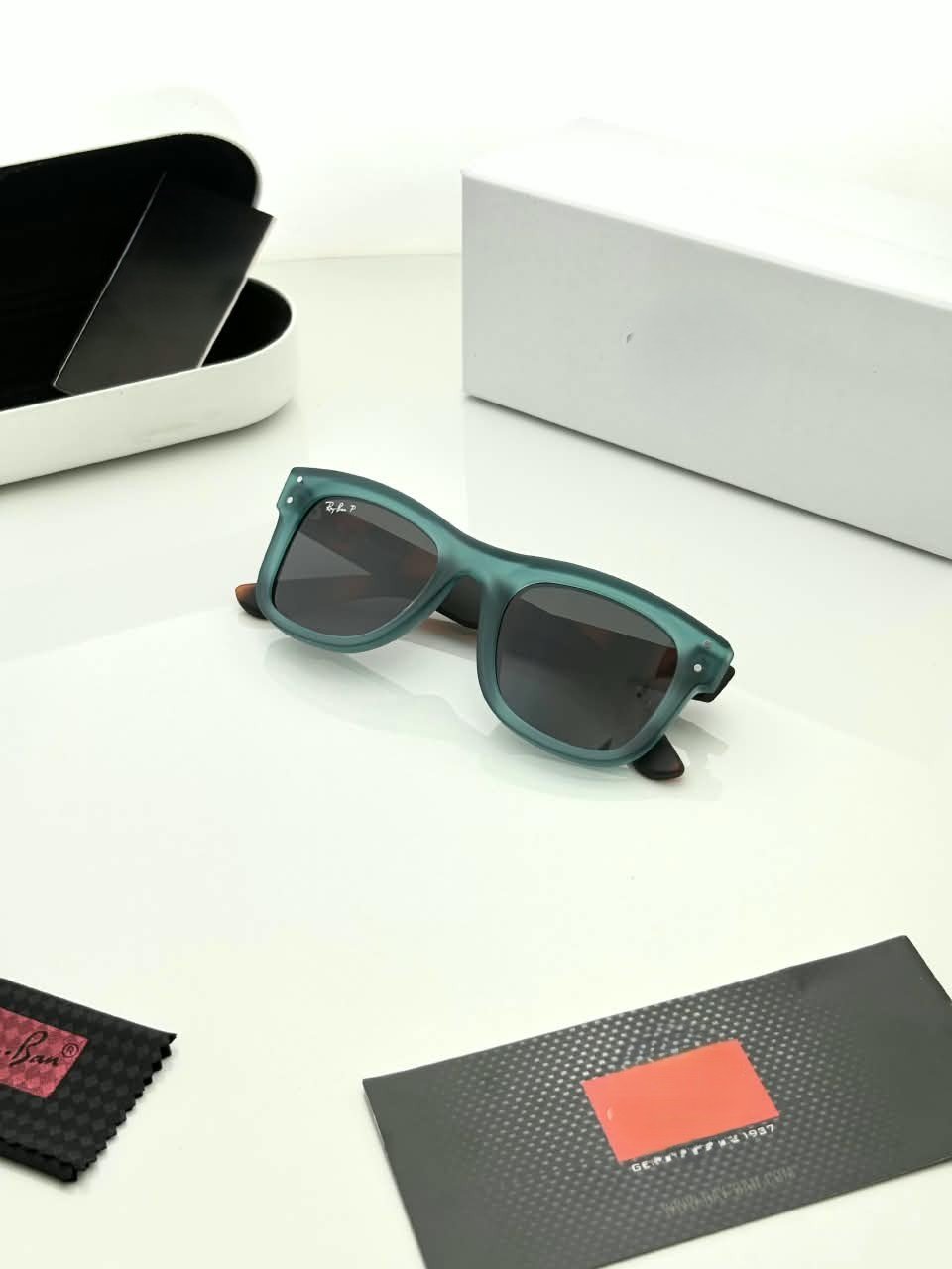 Teal Frame Sunglasses – Dark Grey Lenses (4) Teal rectangular sunglasses with dark grey lenses and brown patterned temples