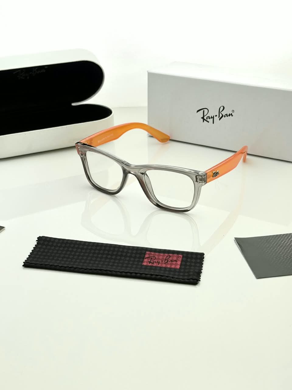Transparent Grey Eyeglass Frames – Orange Temple Design (1) Transparent grey rectangular eyeglass frames with bright orange temples