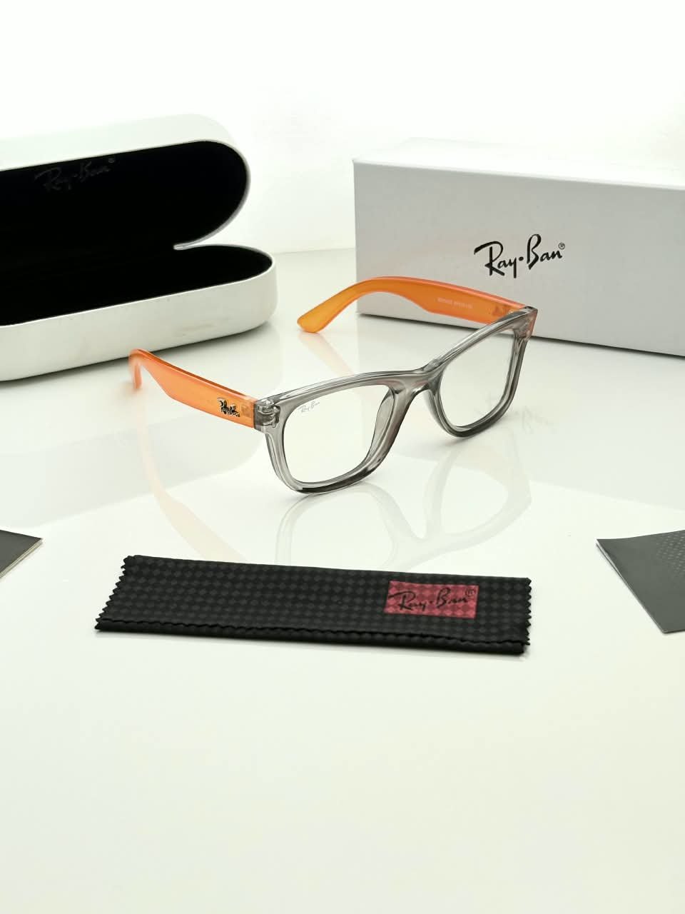 Transparent Grey Eyeglass Frames – Orange Temple Design (2) Transparent grey rectangular eyeglass frames with bright orange temples