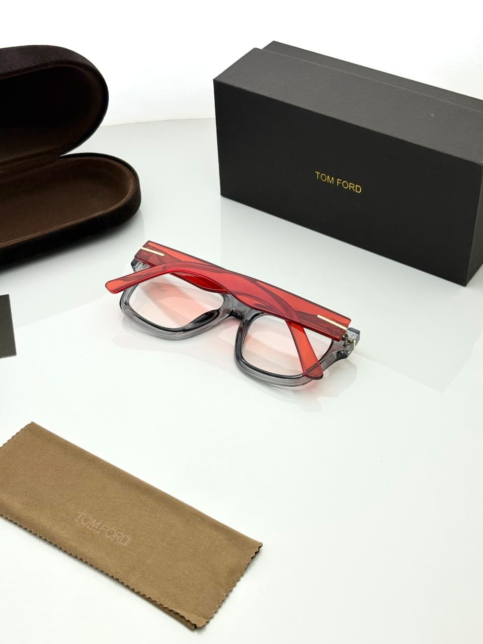 Transparent Grey Eyeglass Frames – Red Temple Design (3) Transparent smoky grey rectangular eyeglass frames with red temples and gold-tone hinge details