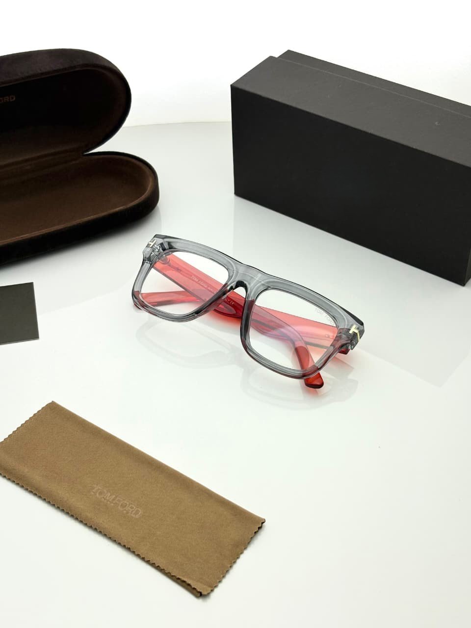 Transparent Grey Eyeglass Frames – Red Temple Design (4) Transparent smoky grey rectangular eyeglass frames with red temples and gold-tone hinge details