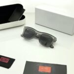Transparent grey sunglasses with dark grey lenses and softly squared frames