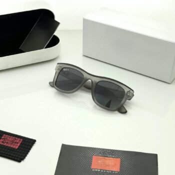 Transparent grey sunglasses with dark grey lenses and softly squared frames