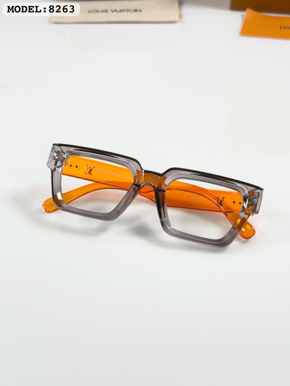 Transparent Square Glasses – Grey Frame with Orange Temples (3) Transparent smoky grey square glasses with bright orange temples and clear-looking lenses